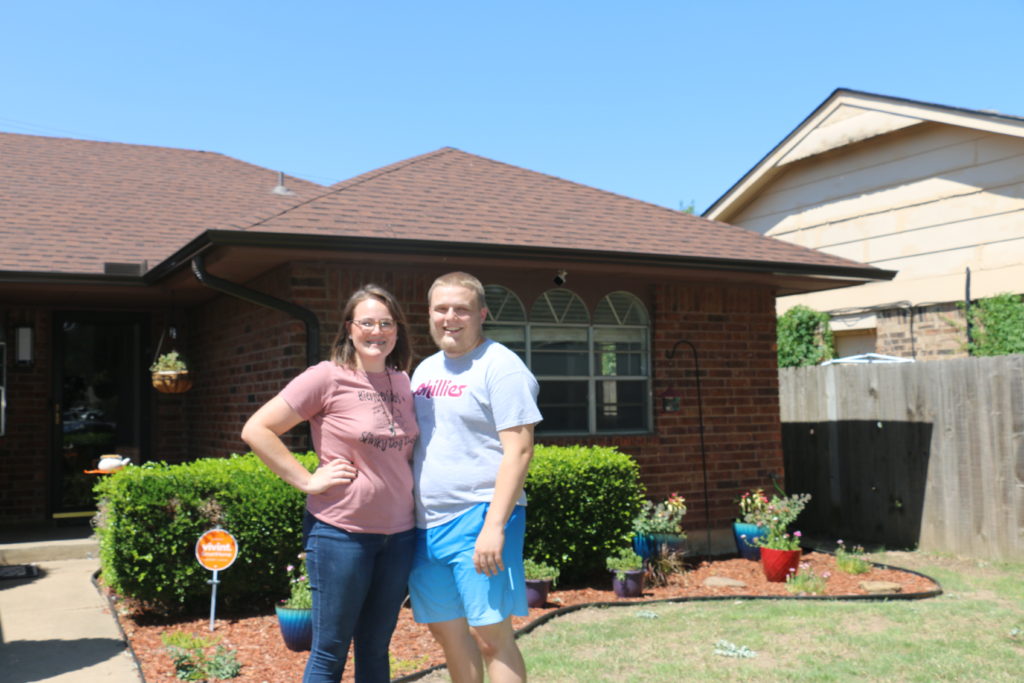 Erin and Jason stand in front of their new home