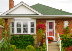 small brick house with green roof