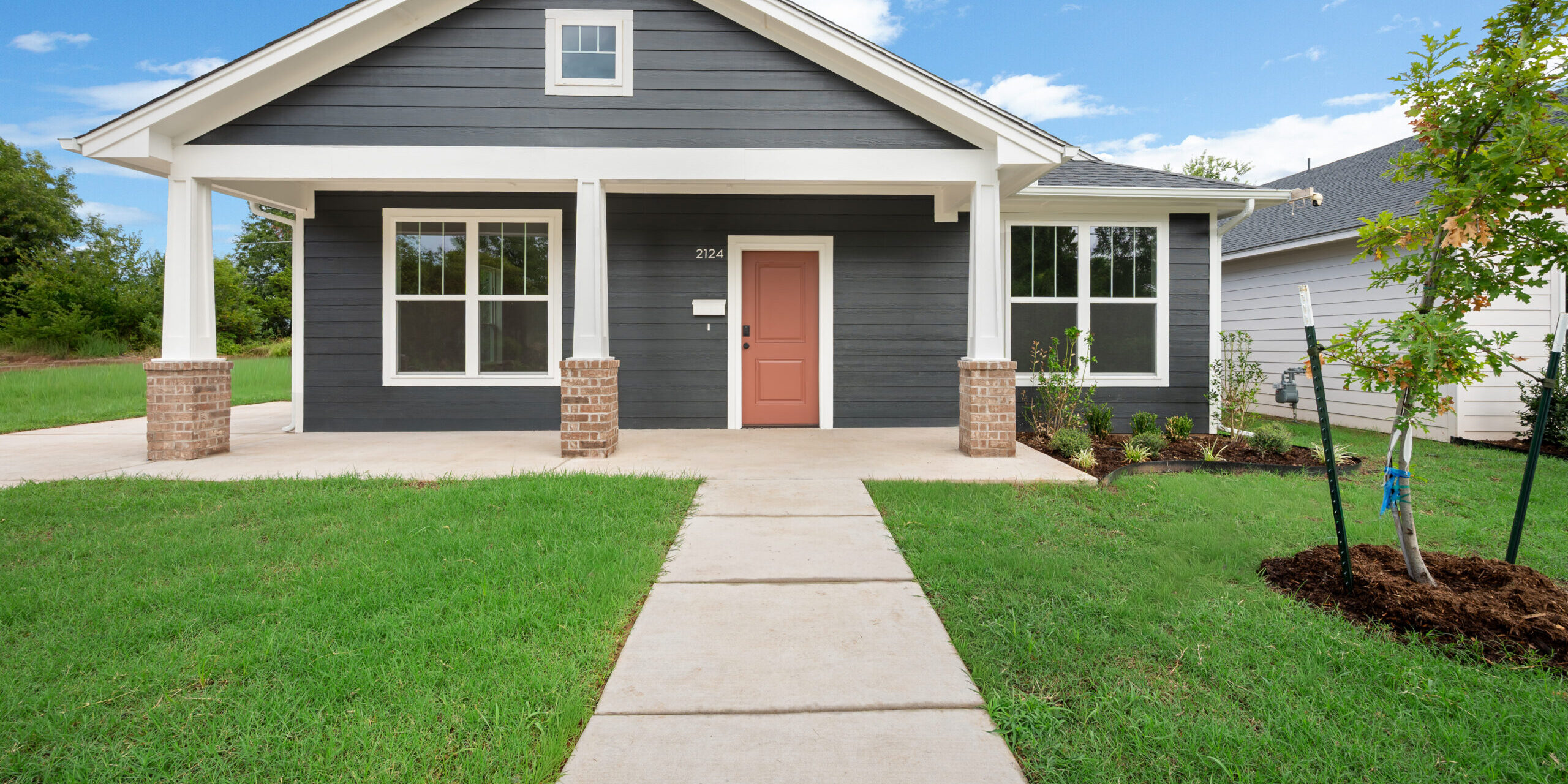 Steel gray one-story home with a green yard in front